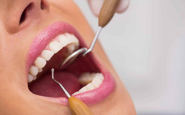 Close up of dentist examining female patient teeth